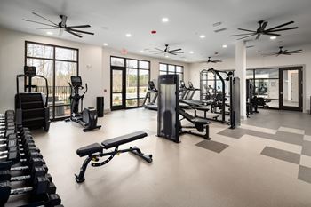 A spacious gym with a variety of equipment including treadmills, weights, and exercise machines.